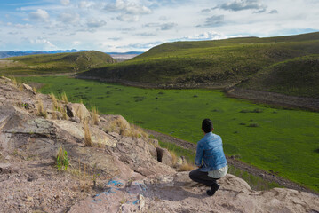 Fototapeta na wymiar Mexican man observes the natural horizon of green forests from the top of a mountain