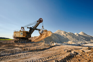 Shovel mining excavator operates in large open chalk quarry