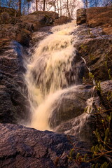 picturesque waterfall on a stream running from the mountains along a ravine on a spring day