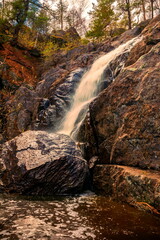 picturesque waterfall on a stream running from the mountains along a ravine on a spring day