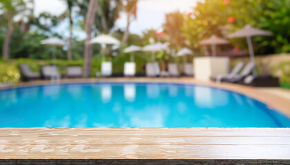 Fototapeta na wymiar Empty table top and blurred swimming pool in tropical resort in summer for display or montage your products.