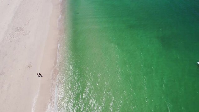 Aerial orbit shot of Conchal beach in Costa Rica. boat sailing on sea.