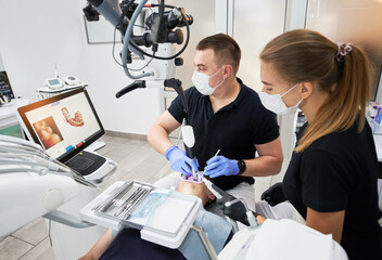 Dentist scanning patient's teeth with modern machine for intraoral scanning. Digital print of...