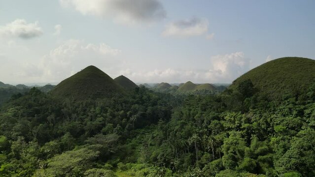 Chocolate hills Philippines landscape with trees and clouds