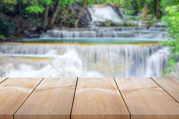 Close-up empty wooden plank long table top on vintage style for put product and anything display with outdoor theme on blurred waterfall summer background