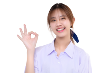Happy Asian student girl in school uniform shows OK hand sign with braces teeth on isolated transparent background. PNG file format.