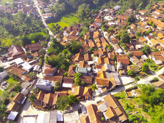 Fototapeta premium Bird's-Eye Cityscape with Dense Residential Area and Greenery. Aerial Drone Shot. Aerial view of a Residential district on the slopes of Mount Pangradinan. Bandung - Indonesia