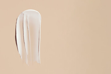 cosmetic smear of creamy texture on a beige background with place for text
