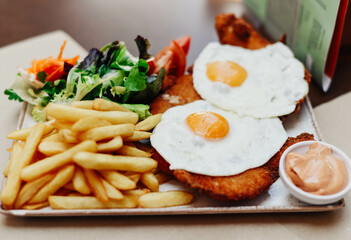 Delicious breaded beef dish with ham, cheese, fried eggs