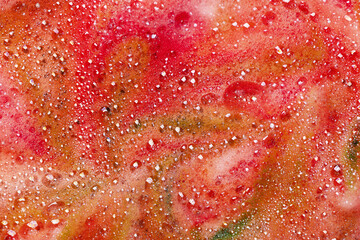 Red soap bubbles foam background. Foam of bath bomb dissolved in water.
