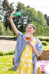Woman with a glass of wine in her hand takes a selfie