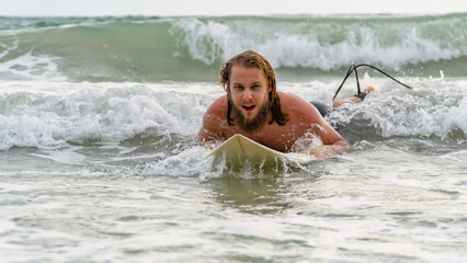 Surfers swimming towards waves in the beach