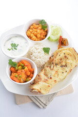 Indian traditional baked roti prata canai with curry vegetables, yogurt sauce, pea bean and steamed white rice  in plate on white background asian halal food vegan cuisine menu for cafe design