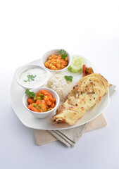 Indian traditional baked roti prata canai with curry vegetables, yogurt sauce, pea bean and steamed white rice  in plate on white background asian halal food vegan cuisine menu for cafe design