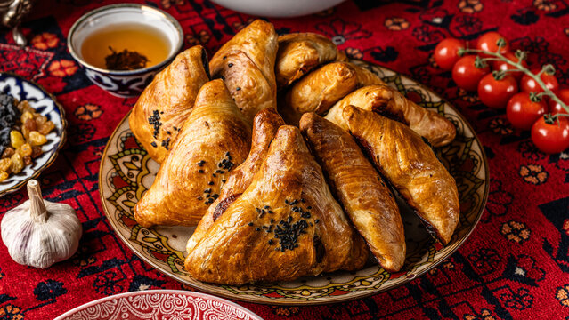 The concept of Eastern cuisine. Uzbek samsa lies on a plate in a restaurant.