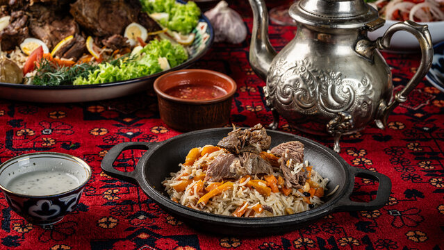 The concept of Eastern cuisine. Samarkand pilaf lies in a cast-iron frying pan in an Uzbek restaurant. background image.