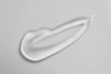 Smear of cosmetic oil on white background, top view