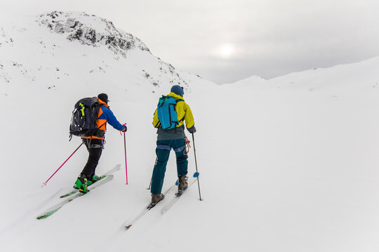 Rear view of two men with backpacks on ski touring in mountains