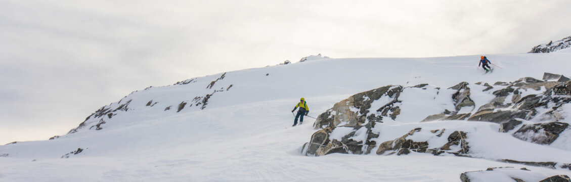 Panoramic view of skiers heading down a backcountry route