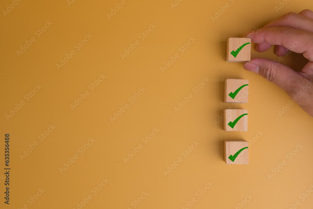 Poster human hand putting cube wood with check mark icon on yellow background with copy space checklist con