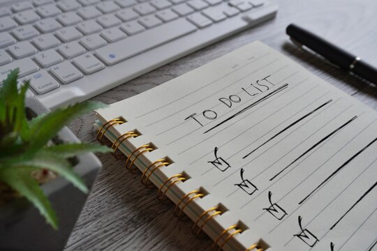 Close up image of notebook with text TO DO LIST on table.