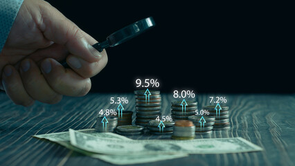 Interest rate and dividend concept, Hand holding magnifying glass coin money with various percentage symbols ,Interest rates continue to increase, rate dividend, stock investment, long term investment