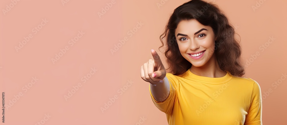 Poster happy teenage girl pointing and smiling drawing attention to an object in empty area