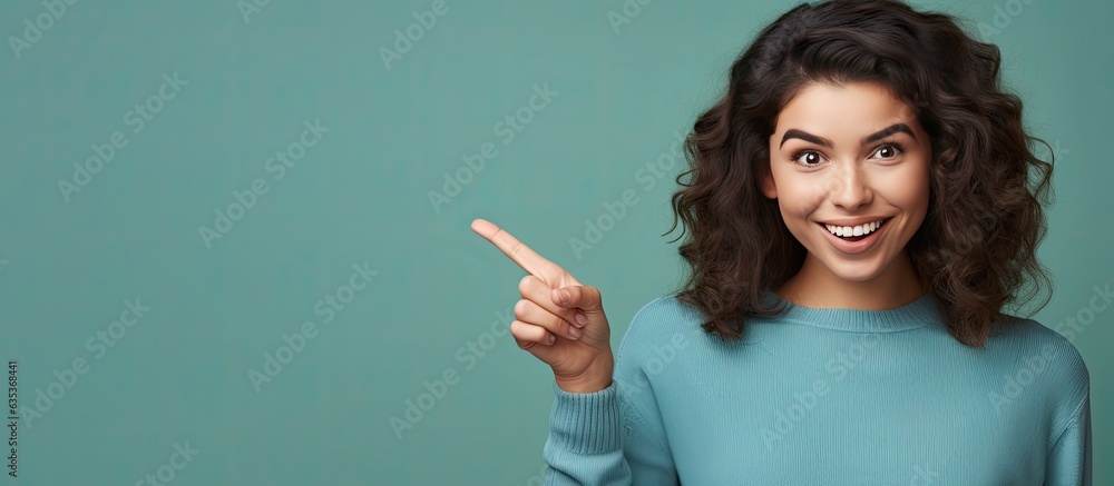 Poster happy teenage girl pointing and smiling drawing attention to an object in empty area