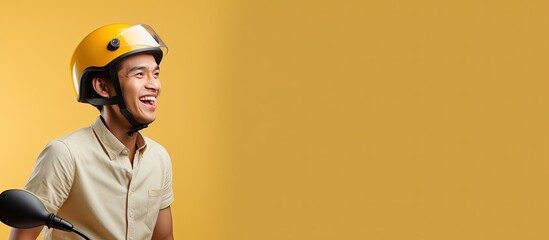 Asian online taxi driver on a motorbike smiling from the side isolated on a yellow background with...