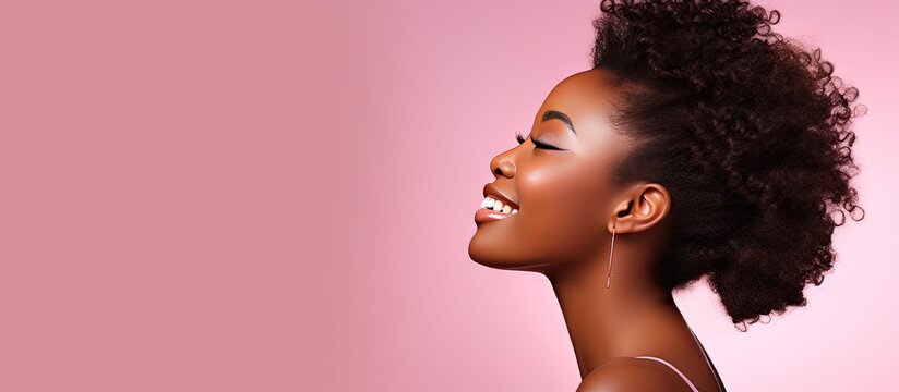 African teenage girl in profile looking at pink studio background with copy space