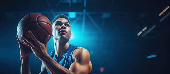 Biracial male basketball player in blue sports attire shooting hoops at the gym Sport activity and lifestyle unchanged Copy space available - Powered by Adobe