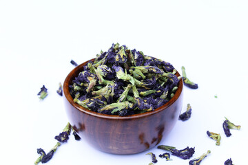 Dried blue butterfly pea flower in a wooden bowl 