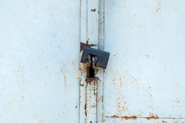 Padlock on metall door. Metal background