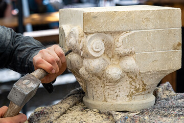 a woman's hands carve in stone
