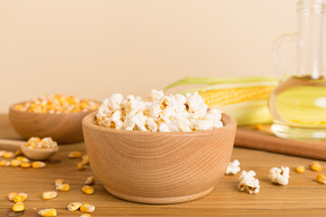 Fototapeta na wymiar Prepared popcorn with ingredients on wooden table