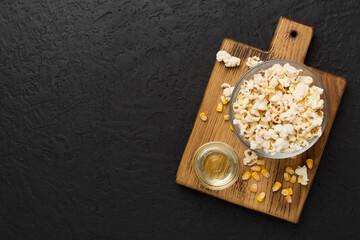 Prepared popcorn with ingredients on concrete background, top view