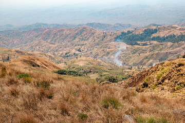 Fototapeta na wymiar View of a valley against mountains seen from Mbeya Peak, Mbeya Mountain range in Mbeya Region, Tanzania