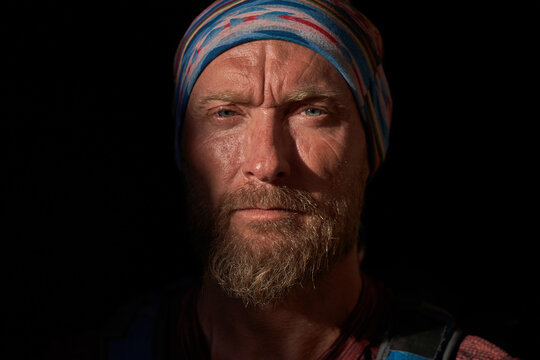 Crop bearded male in bandana in darkness