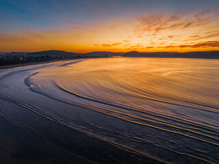 Pretty sunrise at the seaside with high cloud and low tide