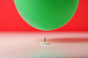 Stationery needle and ball on red background, close up