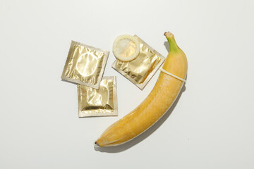 A condom on a banana on a light background