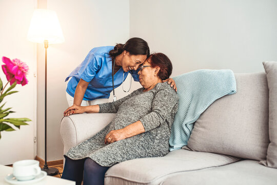 Caregiver with Asian elderly woman at home. Nurse Making Home Visit To Senior Woman For Medical Exam. Portrait of young Asian nurse with elderly woman. Helpful volunteer taking care of senior lady