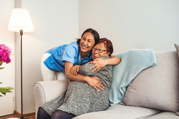 Happy patient is holding caregiver for a hand while spending time together. Elderly woman in...