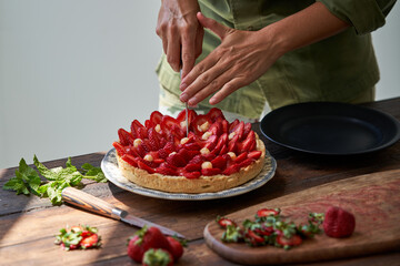 Crop chef cutting strawberry cake