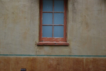 Fototapeta na wymiar A wooden window in an old plaster stone building