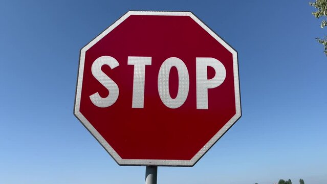 Stop signal in full sun with blue sky. Concept for prohibition, danger, forbidden, depression, protection, bad habits, nostalgia, problem, solitude,advice, control, warning, caution, safety, war, poll