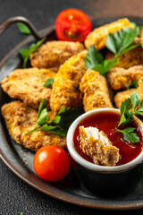 Chicken nuggets with ketchup sauce on a dark background, place for text, top view