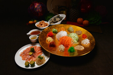 fresh colourful asian festive vegetables salad lo hei yu sheng with smoked salmon, fish skin, cookies and sweet spicy sauce buffet corner for chinese new year halal food menu for banquet restaurant