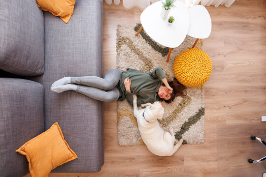 Woman and dog relaxing at home lying on the floor