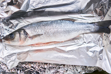 Salmon whole fish on foil ready for baking in the oven. Healthy food cooked at home. Restaurant menu, a series of photos of different dishes